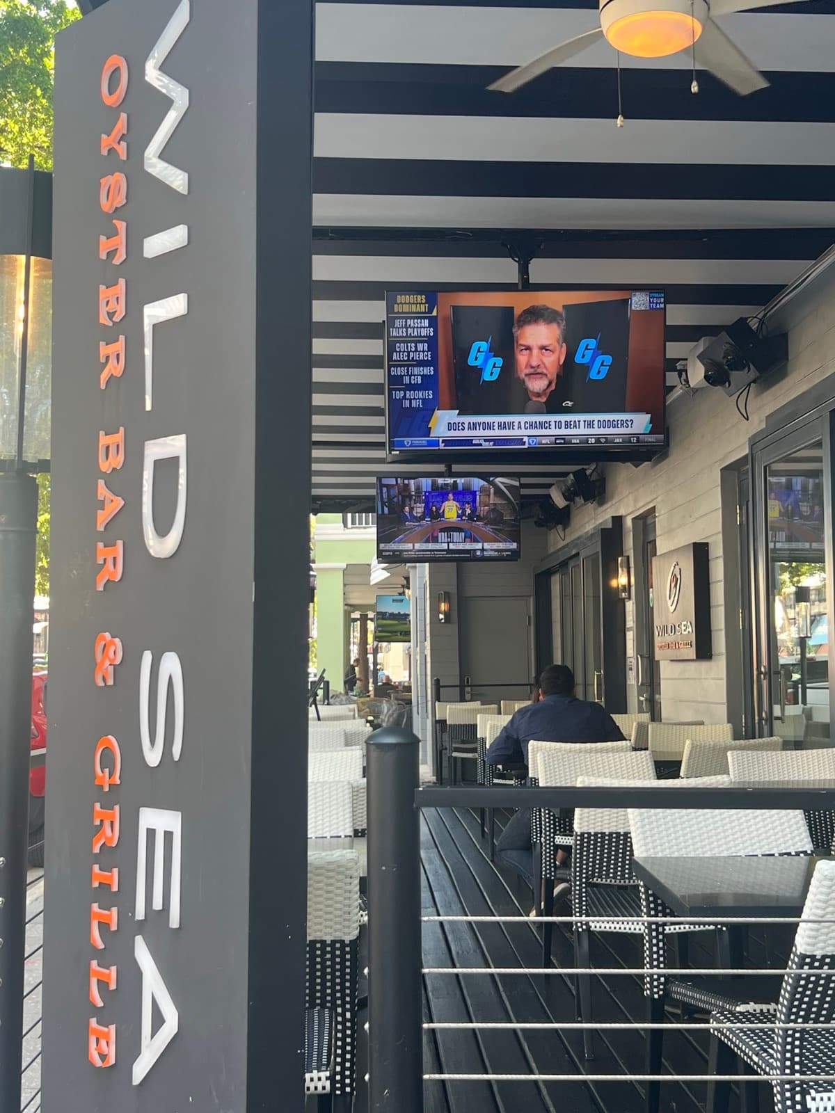 Wild Sea Oyster Bar & Grille signage with mounted TV displaying live sports