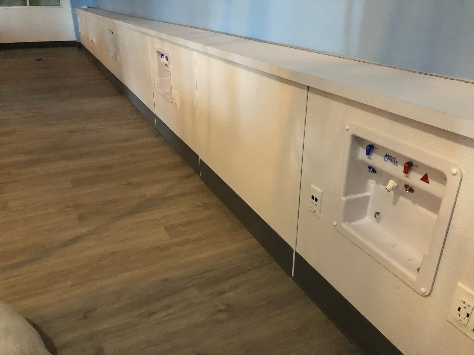 Patient station wall panels with medical and low-voltage outlets along the treatment room