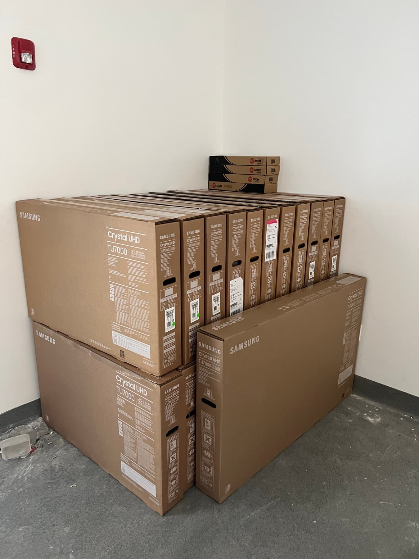Stack of Samsung Crystal UHD televisions ready for installation across patient stations
