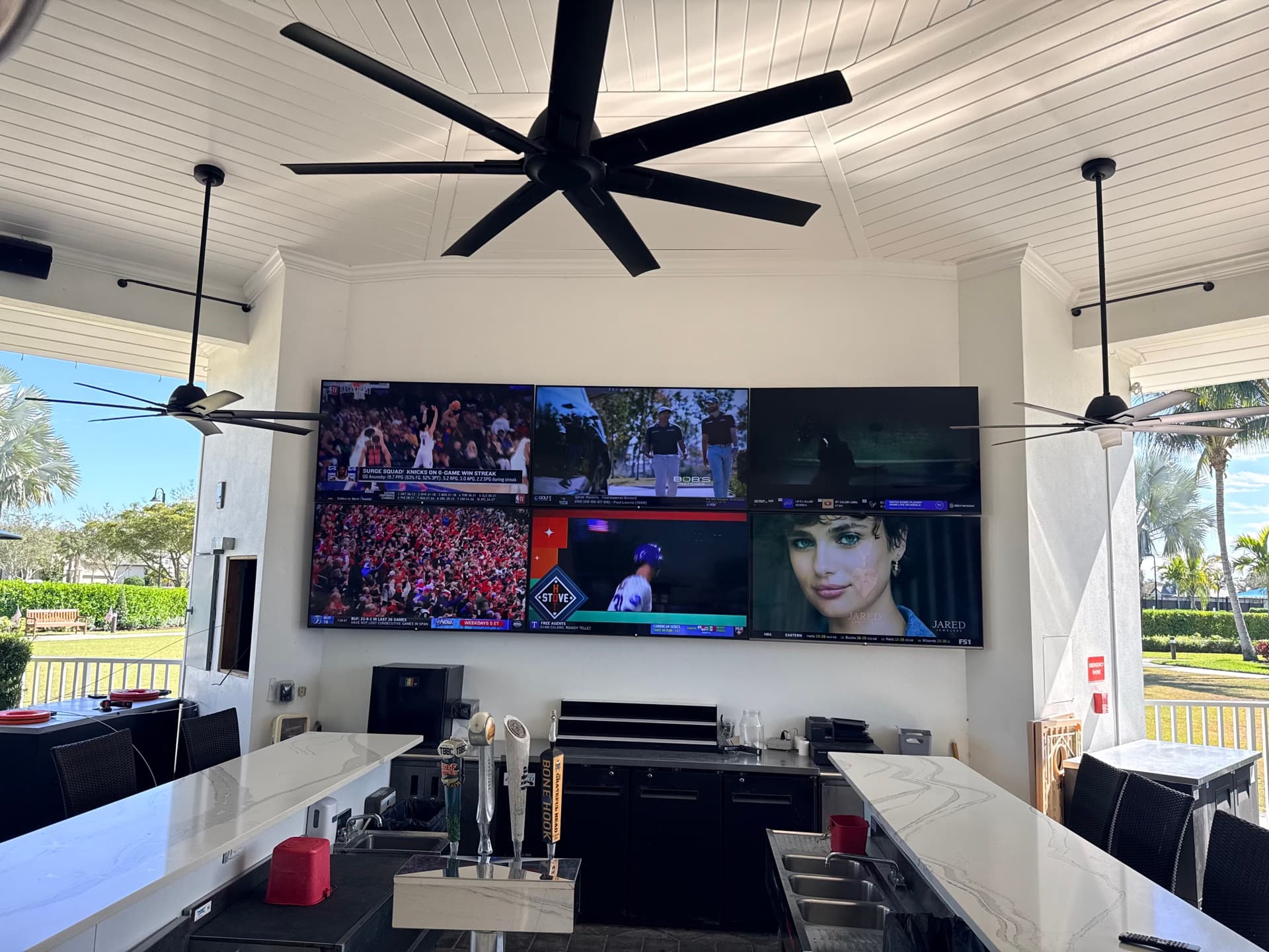 Luxury outdoor bar with multi-screen TV wall installed by Axis