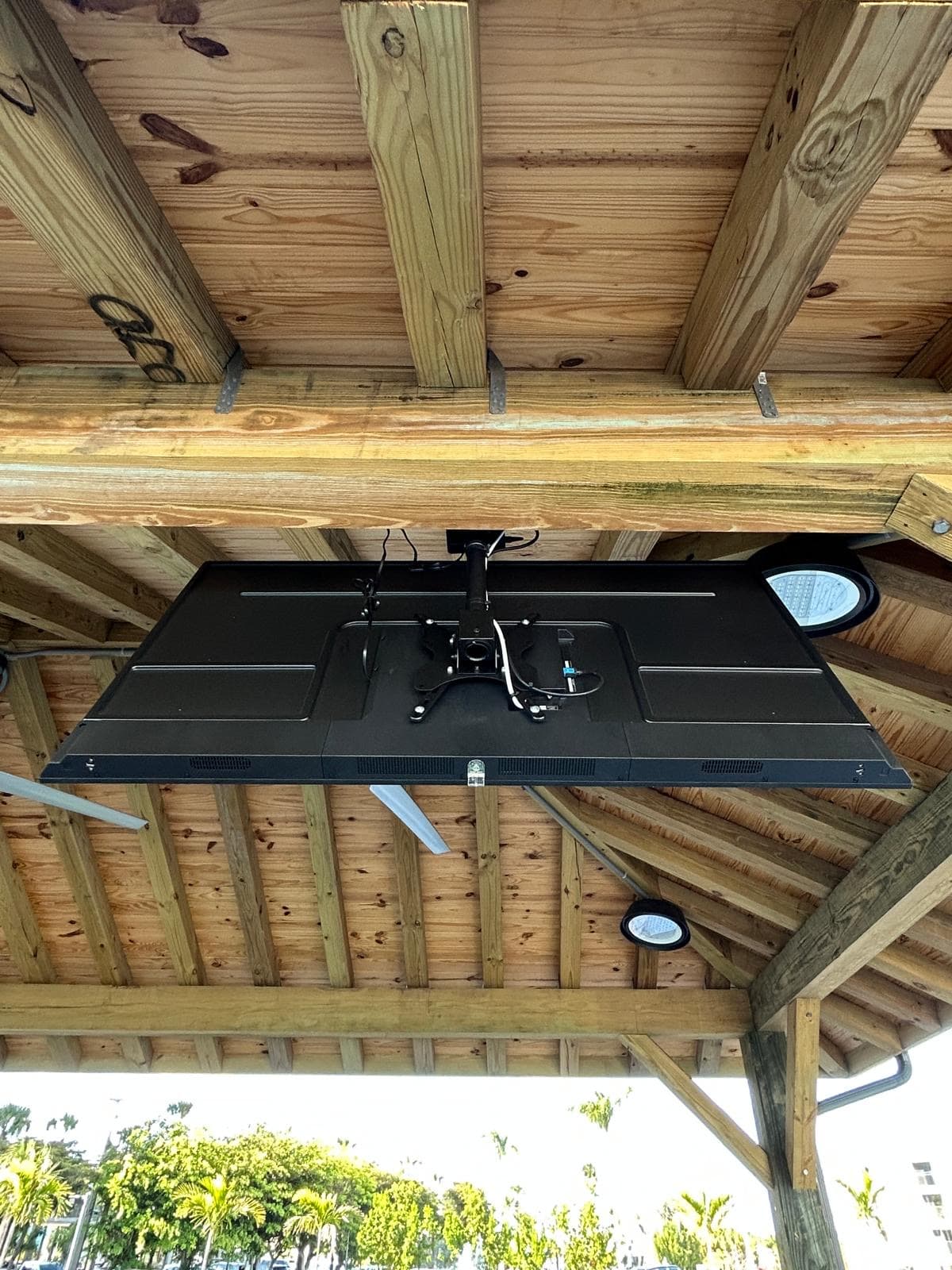 Heavy-duty TV mount and bracket detail beneath the pavilion roof