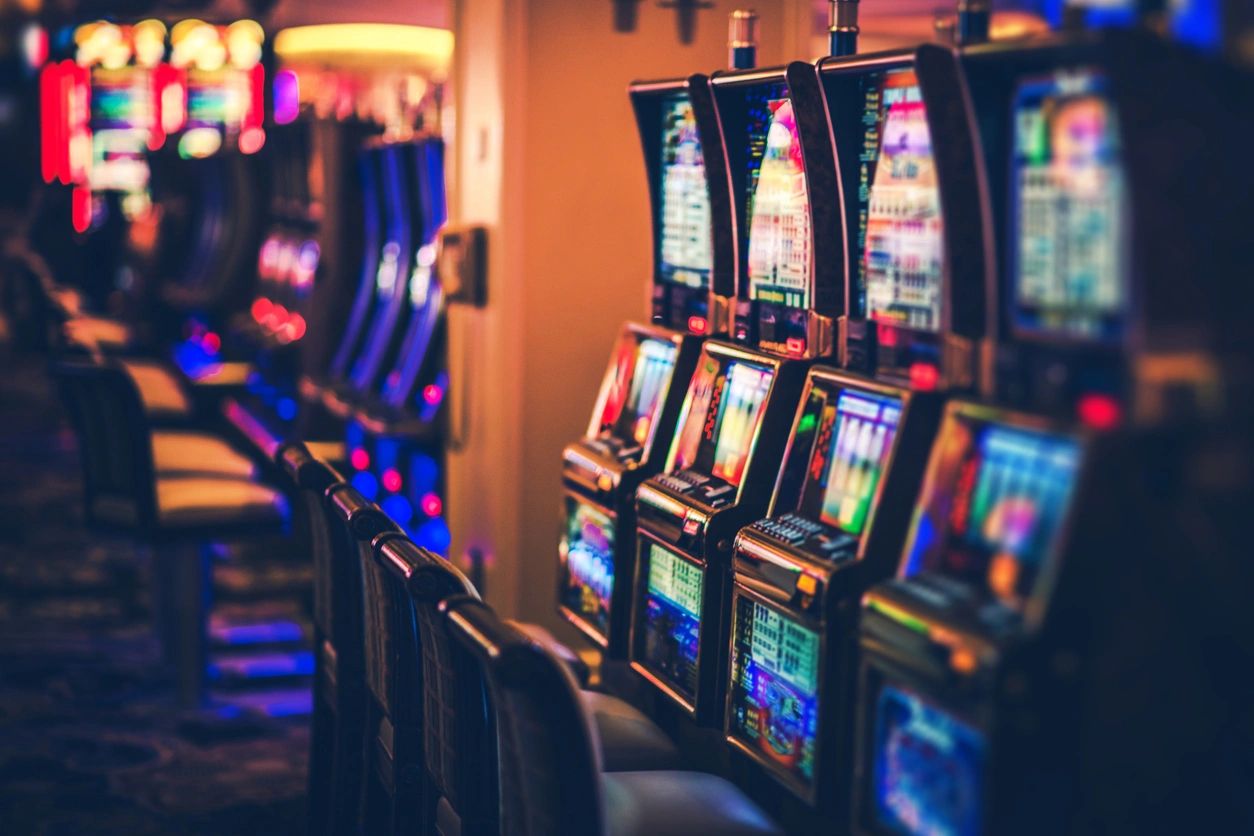 Row of illuminated slot machines in a casino.